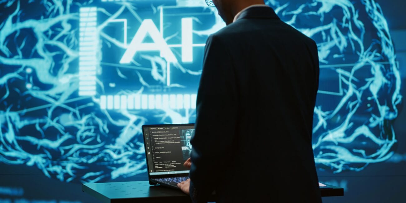 AI system administrator using laptop device in high tech futuristic workspace. Man working on notebook to automatize tasks using artificial intelligence technology, camera A