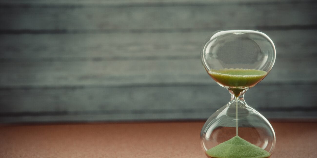 Sand running through the bulbs of an hourglass measuring the passing time in a countdown to a deadline, on a blur background with copy space