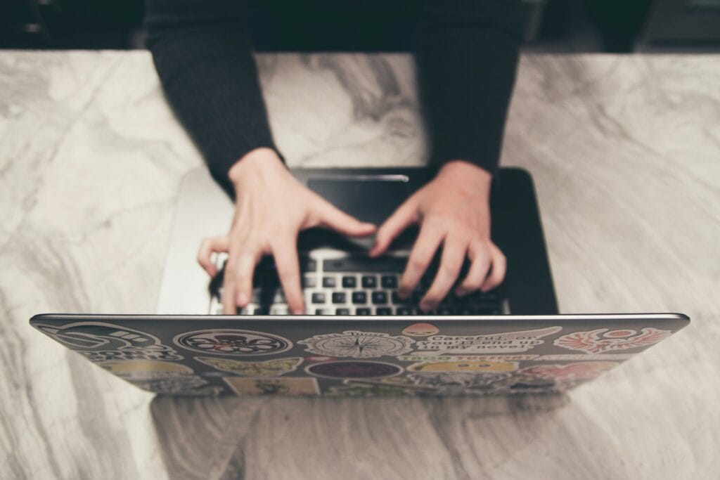 A professional working at a laptop on a marble desk, representing the process of creating valuable blog content for a business website.